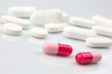 Obraz na płótnie Canvas Pharmacy theme. Pink and white antibiotic pills.