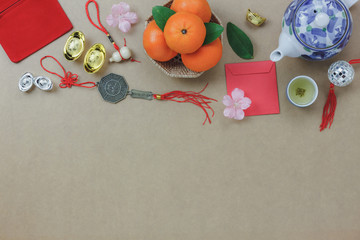 Above view of top decorations Chinese New Year festive background concept.Mix variety essential accessory on modern grunge brown table house office desk.Other language mean rich or wealthy and happy.