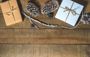 Boxes with gifts, cones, free space  on a wooden background