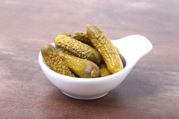 Pickles. Bowl of pickled gherkins cucumber with copy space. Cornichons.