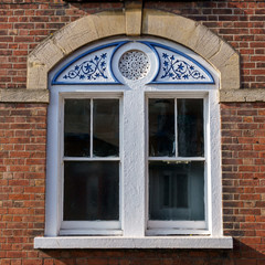 facade window with wooden carved ornamental decoration in white and blue colores, Exeter, February 18, 2017