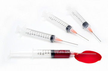 Syringe with blood on a white background close up