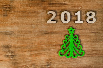 Green Christmas tree and sign 2018 from wooden letters, symbol of wooden texture background. Happy new year 2018 backdrop. Greeting card.