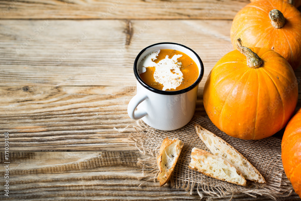 Wall mural Pumpkins soup with cream and bread and pumokins