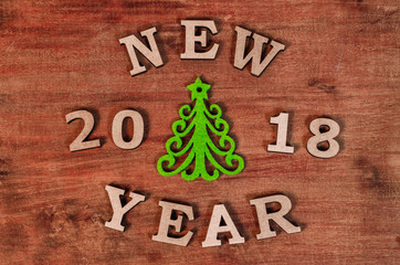 Fototapeta premium Green Christmas tree and sign 2018 New year from red wooden letters, symbol of wooden texture background. Happy new year 2018 backdrop.Greeting card