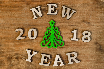 Green Christmas tree and sign 2018 New year from wooden letters, symbol of wooden texture background. Happy new year 2018 backdrop.Greeting card