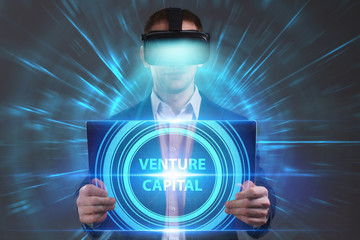 Business, Technology, Internet and network concept. Young businessman working in virtual reality glasses sees the inscription: Venture capital