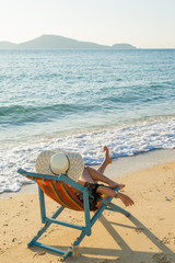 Fototapeta na wymiar woman relaxing on sun bed sofa lounge chair on holidays