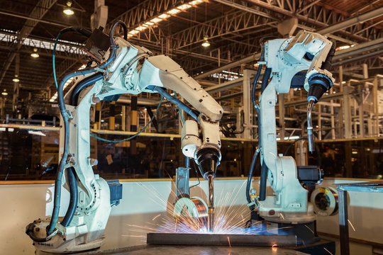 Team industrial robot are welding in automotive industrial factory