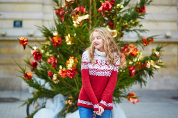 Young woman on a street of Paris decorated for Christmas