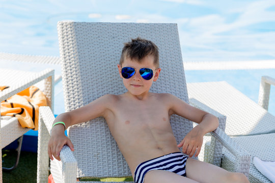 Young Boy In A Swimsuit On A Shelf By The Pool