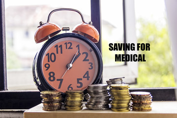 Clock and coin with the word SAVING FOR MEDICAL - the concept of savings