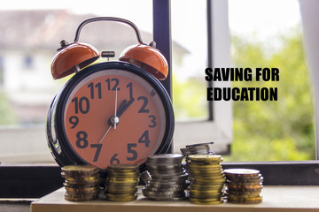 Clock and coin with the word SAVING FOR EDUCATION - the concept of savings