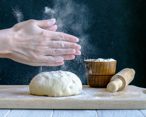 Hands clapping and sprinkling flour over dough