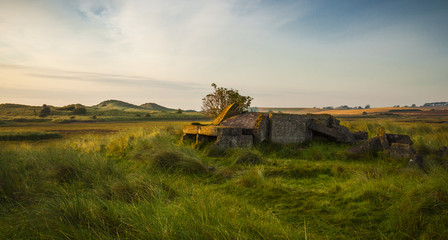 Naklejka premium Ruins of World War 2 Pillbox at Alnmouth, on the coast of Northumberland, England, UK. In the early morning sunlight.
