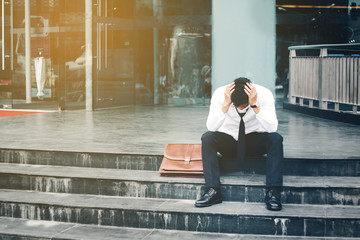 Unemployed Tired or stressed businessman sitting on the walkway after work Stressed businessman concept