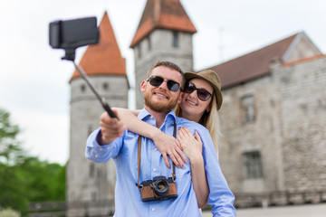 travel concept - happy tourists taking photo with smart phone