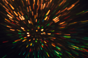 Abstract background of colorful lines in motion on black. Bokeh of defocused splashes, blurred yellow and green neon leds, fireworks and salute, space and sky backdrop