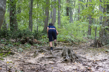 The boy runs and climbs up the hill