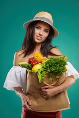 Happy Woman Holding Grocery Shopping Bag With Vegetables On Colored Background