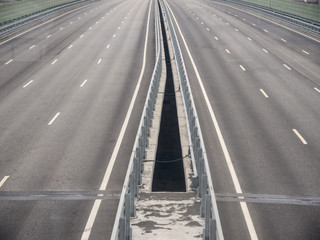 A part of four lanes asphalt highway bridge with gap between flows