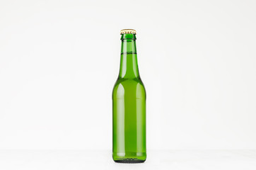 Green longneck beer bottle 330ml, mock up. Template for advertising, design, branding identity on white wood table.