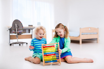 Kids playing with wooden abacus. Educational toy.