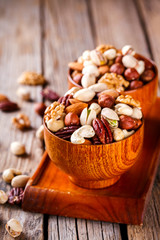 Nuts Mixed in a wooden plate.Assortment, Walnuts,Pecan,Almonds,Hazelnuts,Cashews,Pistachios.Concept of Healthy Eating.Vegetarian.selective focus.