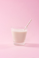 Dairy products. A glass of milk on a pink background.