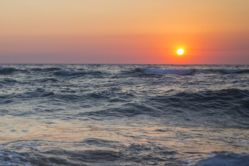 Il sole che tramonta nel mare è sempre una bella chiusura per una giornata di vacanza. Le tonalità calde donate dal sole si scontrano con il blu delle acque agitate del mare.