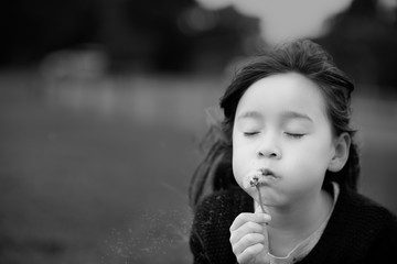Girl blowing dandelions
