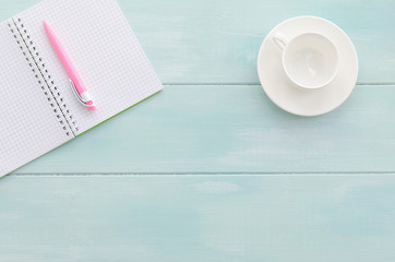 Open notebook with pink pen and coffee cup