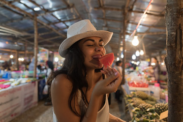 Beautiful Young Woman Tasting Watermelon On Traditional Street Market In Asia Girl Tourist Buying Fresh Fruits On Thailand Bazaar Concept