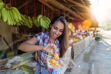Beautiful Girl Eating Exotic Fruits On Traditional Street Market Happy Smiling Attractive Female...