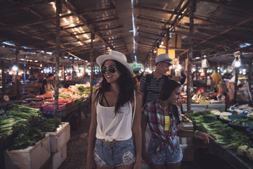 Tourists Walking Between Rows On Tropical Exotic Market Young People Choosing Fresh Fruits And...