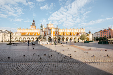 Fototapeta na wymiar Wide angle view on the Market square with Cloth Hall building and Adam Mickiewicz monument during the morning light in Krakow, Poland