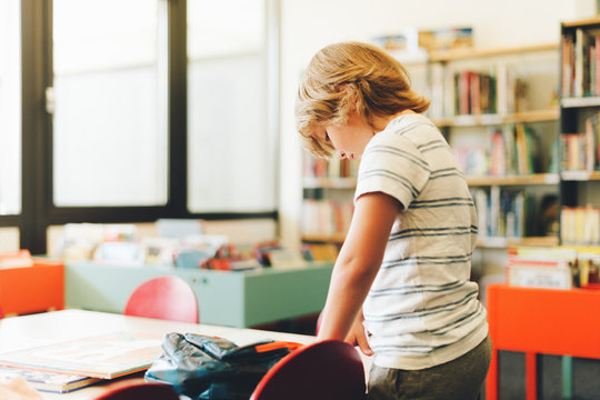 Sweet Little Boy Packing Backpack In Classroom, Education For Children