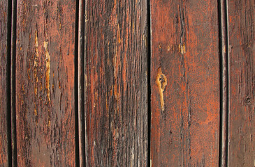 Texture of old wood with cracked paint of dark red color
