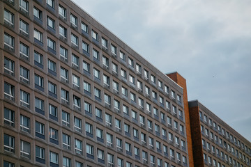 old plattenbau building on darken cloudy background