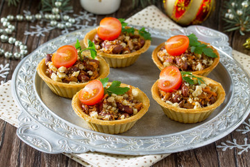 Tartlets with beans, meat and walnuts. Beautiful Christmas and New Year's food background. Selective focus.