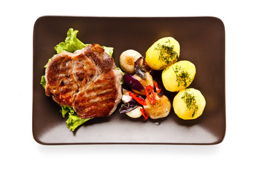 Roast steak with potatoes on white background