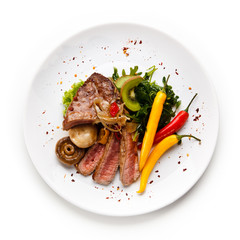     Fillet mignon - grilled beefsteaks with vegetables on white background 