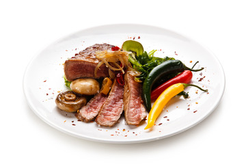     Fillet mignon - grilled beefsteaks with vegetables on white background 
