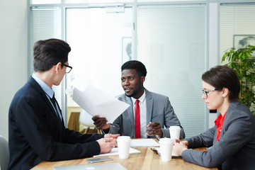 Confident employers interviewing one of candidates for new vacancy