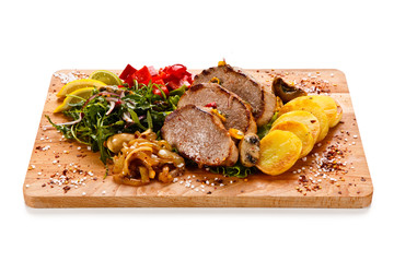 Roast steak with potatoes on cutting board