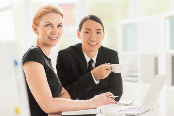 Obraz premium Happy entrepreneurs sitting in office while planning or discussing new project