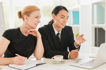 Business people discussing online financial information for report