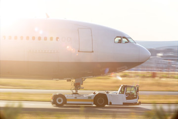 an airplane beeing towed with a modern towing vehicle