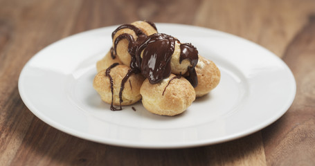 profiteroles with fine dark chocolate on plate