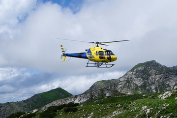 Fototapeta na wymiar Hubschrauber im Flug im Allägu in den Bergen